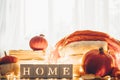 Background with warm sweaters and the inscription HOME. Pile of knitted clothes with leaves, pumpkins. Coziness. Autumn concept Royalty Free Stock Photo