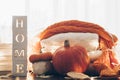 Background with warm sweaters and the inscription HOME. Pile of knitted clothes with leaves, pumpkins. Coziness. Autumn concept Royalty Free Stock Photo