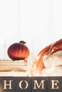 Background with warm sweaters and the inscription HOME. Pile of knitted clothes with leaves, pumpkins. Coziness. Autumn concept Royalty Free Stock Photo