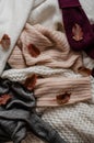 Background with warm sweaters. Pile of knitted clothes with autumn leaves, space for text, Autumn winter concept. Copy Space. Royalty Free Stock Photo