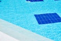 Background of water in blue swimming pool, water surface with a sun reflection