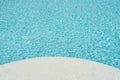 Background of water in blue swimming pool, water surface with a sun reflection