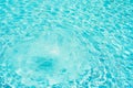 Background of water in blue swimming pool, water surface with a sun reflection