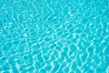 Background of water in blue swimming pool, water surface with a sun reflection