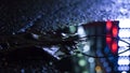 Background of wet asphalt with neon light. Blurred background, night lights of a big city, reflection, puddles.
