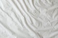 Background of white rumpled sheets. Bed linen with wrinkles in day light. Horizontal. Copy space. Concept of rest, awakening,