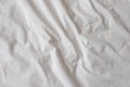 Background of white rumpled sheets. Bed linen with wrinkles in day light. Horizontal. Copy spase. Concept of rest, awakening,