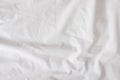 Background of white rumpled sheets. Bed linen with wrinkles in day light. Horizontal. Copy spase. Concept of rest, awakening, Royalty Free Stock Photo