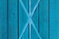Background of a wooden fence with vertical boards and metal cross beams with blue peeling paint close-up, the old door of a Royalty Free Stock Photo