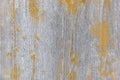 Background of a wooden gray surface with the remains of yellow paint.Close up