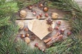 Background with wooden heart, pine branches, nuts, cinnamon sticks and star anise in an old wooden table. Space for text. Royalty Free Stock Photo