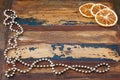 Background wooden table with christmas chaplet and pieces of dried orange Royalty Free Stock Photo