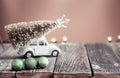 Background with wooden table and little VW toy car carrying Christmas tree Royalty Free Stock Photo