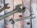 Background with wrenches and nuts on wooden boards. Adjustable wrenches and spanners. Nuts of different sizes.