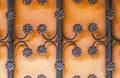 Background - Wrought iron decorative grill with flower motifs against a motled orange adobe wall Royalty Free Stock Photo