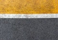 Background of yellow black strips . Dark grey asphalt road divided by yellow paint