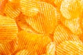 Background of yellow golden grooved fried potato chips