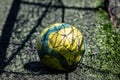 Background. yellow and green soccer ball on a synthetic five-a-side football field with the shadow of the goal net