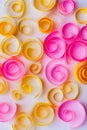 Background with yellow and pink paper spirals and swirls, paper art; greeting/anniversary card concept Royalty Free Stock Photo