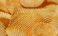 Background with yellow potato chips riffle. Close-up view. Natural product