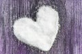 Heart made of snow on a wooden background Royalty Free Stock Photo