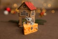Backgrounds and textures. A toy mouse sits in cheese on a brown starry background, a small wooden house and Christmas Royalty Free Stock Photo