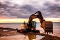 Backhoe or digger working with bucket at industrial earth excavation site