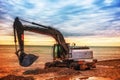 Backhoe or digger working with bucket at industrial earth excavation site