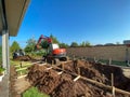 A backhoe digging a hole for a pool behind a house in Orlando, Florida