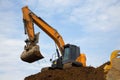 backhoe digging hydraulic shovel on construction site earth mover excavator dumping earth Royalty Free Stock Photo