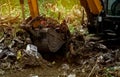 Backhoe digging soil at construction site. Bucket of backhoe digging soil. Clearing and grubbing. Digger working at road