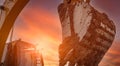 Backhoe digging soil at construction site. Dirt bucket of backhoe digging soil with yellow sunset sky. Crawler excavator digging Royalty Free Stock Photo