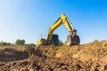 Backhoe digging up soil to prepare agricultural land