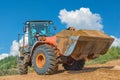 Backhoe loader or bulldozer - excavator with clipping path on a background with blue sky and clouds. work on construction site or Royalty Free Stock Photo