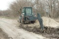 Backhoe loader digging hole, road works.