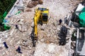 The backhoe machinery working on site demolition of an old building workers spray water to get rid of dust Royalty Free Stock Photo