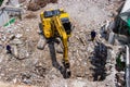 The backhoe machinery working on site demolition of an old building workers spray water to get rid of dust Royalty Free Stock Photo