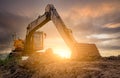 Backhoe parked at construction site after digging soil. Bulldozer on sunset sky and clouds background. Digger after work. Earth Royalty Free Stock Photo