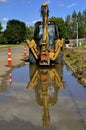 Backhoe reflects in the water