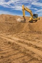 Backhoe on the sand against the sky. Royalty Free Stock Photo