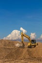 Backhoe on the sand cloud sky. Royalty Free Stock Photo