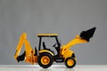 Backhoe tractor toy, grey background