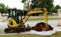 Backhoe on upscale neighborhood street Royalty Free Stock Photo