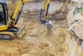 Backhoe on work digs ground during earthworks for the foundation Royalty Free Stock Photo