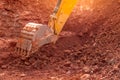 Backhoe working by digging soil at construction site. Bucket of backhoe digging soil. Crawler excavator digging on dirt. Closeup Royalty Free Stock Photo