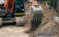 Backhoe working by digging soil at construction site. Bucket teeth of backhoe digging sand. Crawler excavator digging on soil. Royalty Free Stock Photo