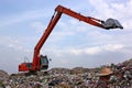 Backhoe working on garbage dump at landfill. People Working at a