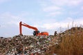 Backhoe working on garbage dump at landfill. People Working at a