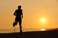 Backlight of a man running on the beach at sunset Royalty Free Stock Photo