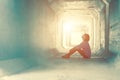 Backlight of a teenager depressed sitting inside a dirty tunnel Royalty Free Stock Photo